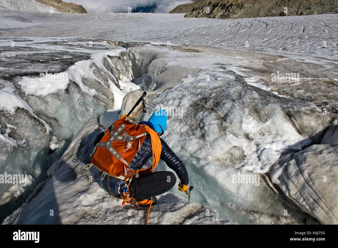 Alpinist examing eine Gletscherspalte auf dem Plateau du Trient, Wallis, Schweiz Stockfoto