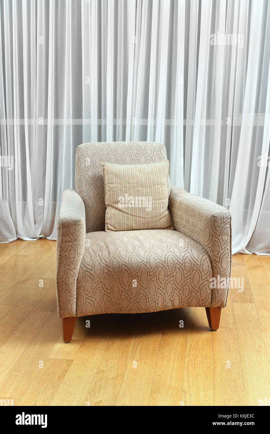Retro Textil Sessel im Zimmer mit weißen Vorhängen Stockfoto