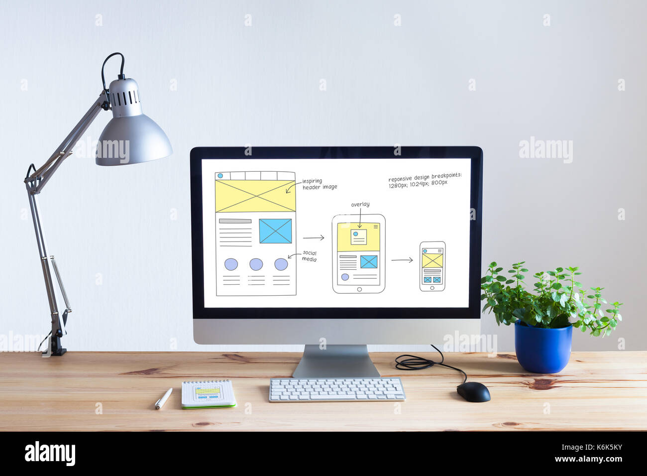Reaktionsschnelle web design Entwicklung Technologie Konzept mit Desktop Computer in moderne, helle Büro- und website Drahtmodell Skizze Layout auf dem Bildschirm, nobo Stockfoto