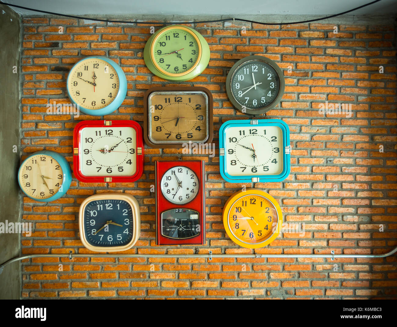 Mehrere Uhren auf eine Mauer mit unterschiedlichen Zeiten. Stockfoto
