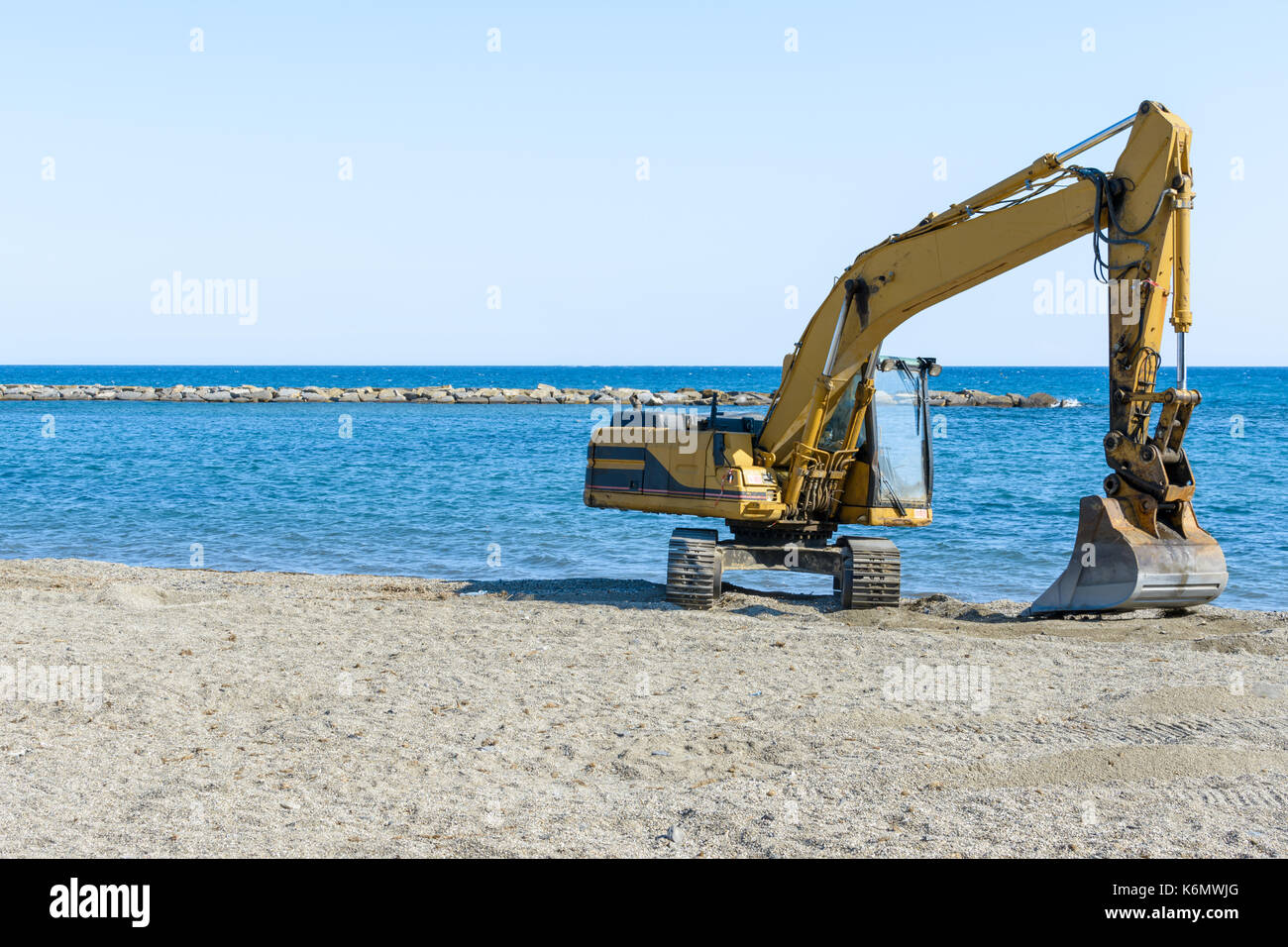 Bagger, dass Arbeiten am Strand ist der Sand vor Beginn der Sommersaison zu glätten Stockfoto