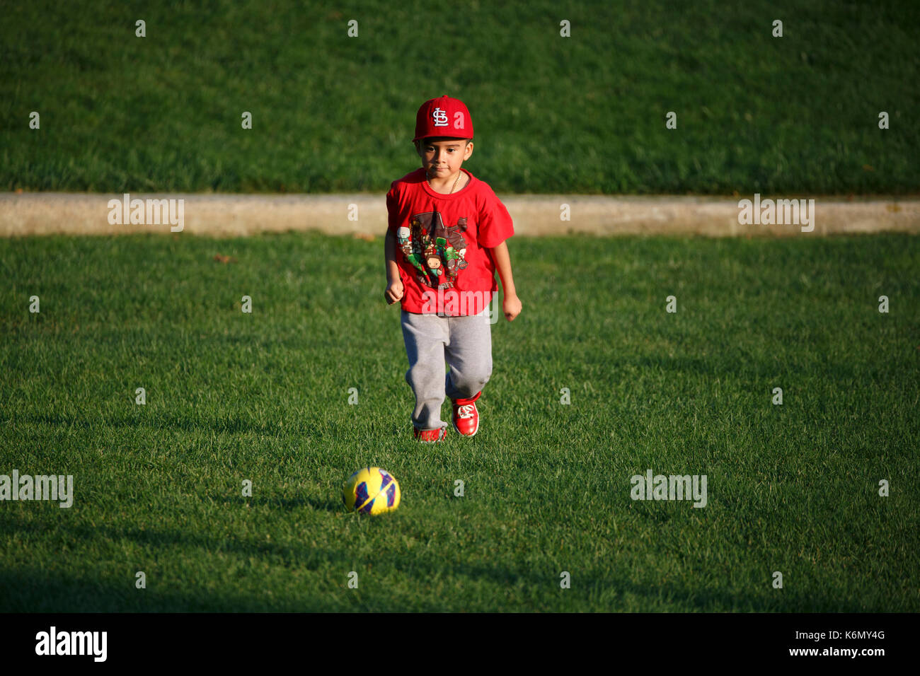 Jungen spielen mit Fußball im City Park Stockfoto