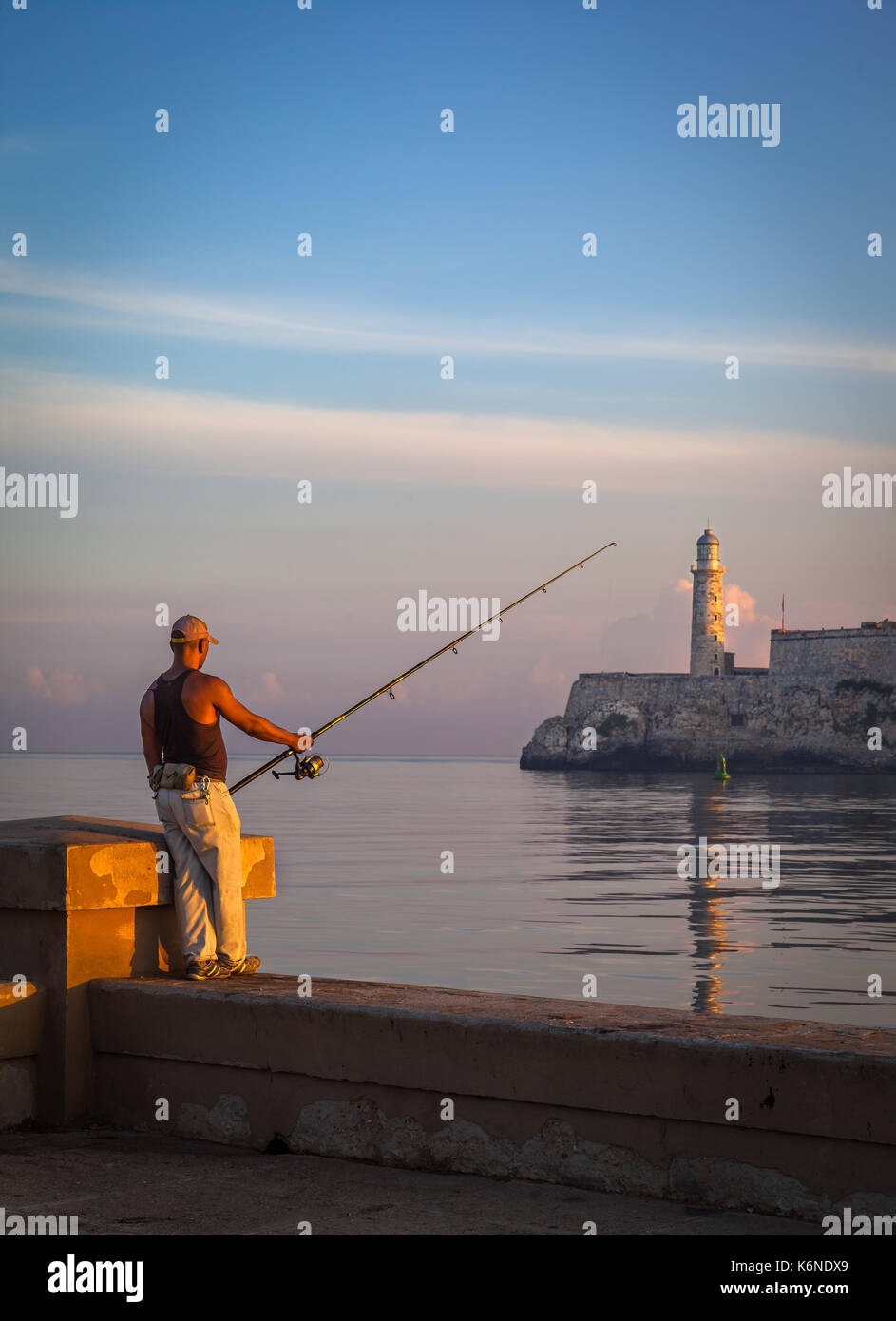 Kubanische Mann angeln vor der berühmten Festung El Morro, Havanna, Kuba Stockfoto