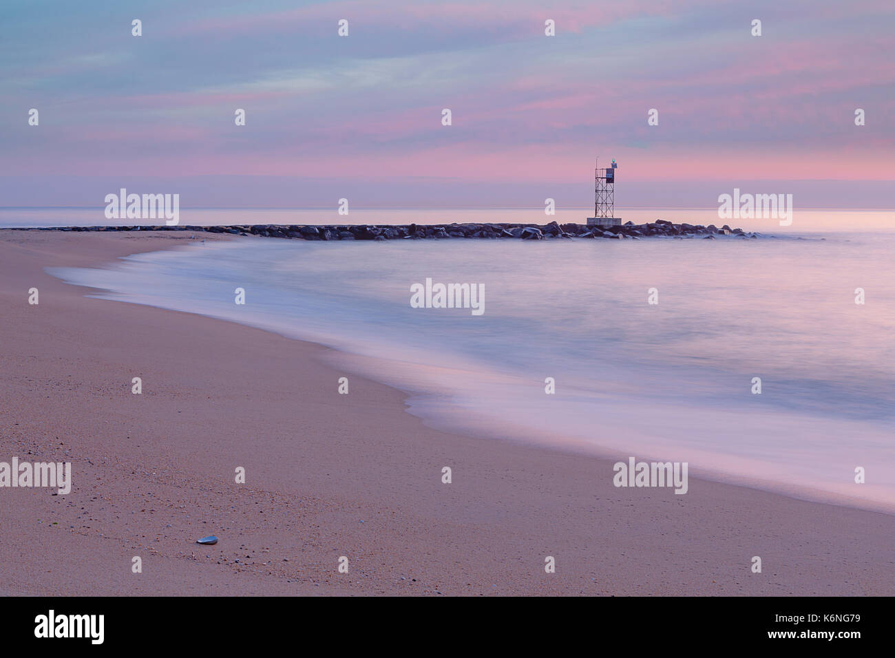 NJ Ufer Jetty First Light - das Weiche Pastelltöne bei Tagesanbruch das Seascape geben eine friedliche und ruhige Gefühl an der New Jersey Shore Jetty. Stockfoto