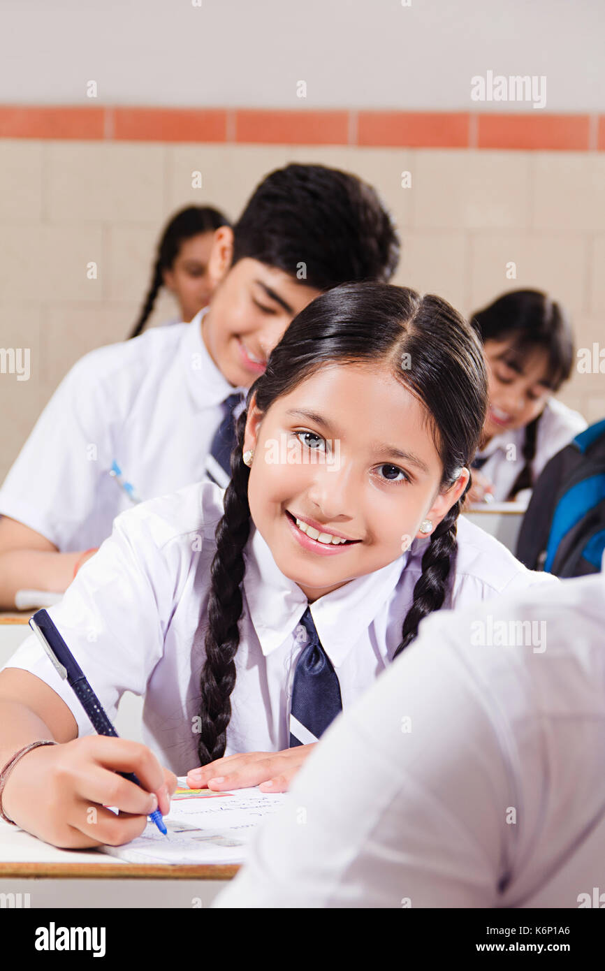 Lächelnd Indian School Kid Mädchen Student Hinweis Buch schreiben Studium Ausbildung im Klassenzimmer Stockfoto