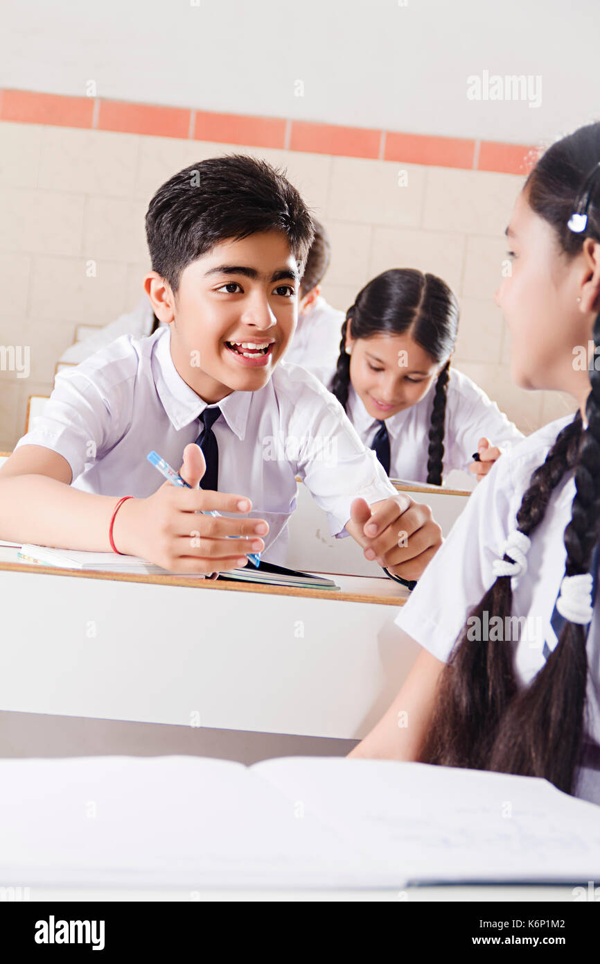 2 indischen Jungen und Mädchen der Schule Schüler sitzen in der Klasse sprechen Klatsch Stockfoto