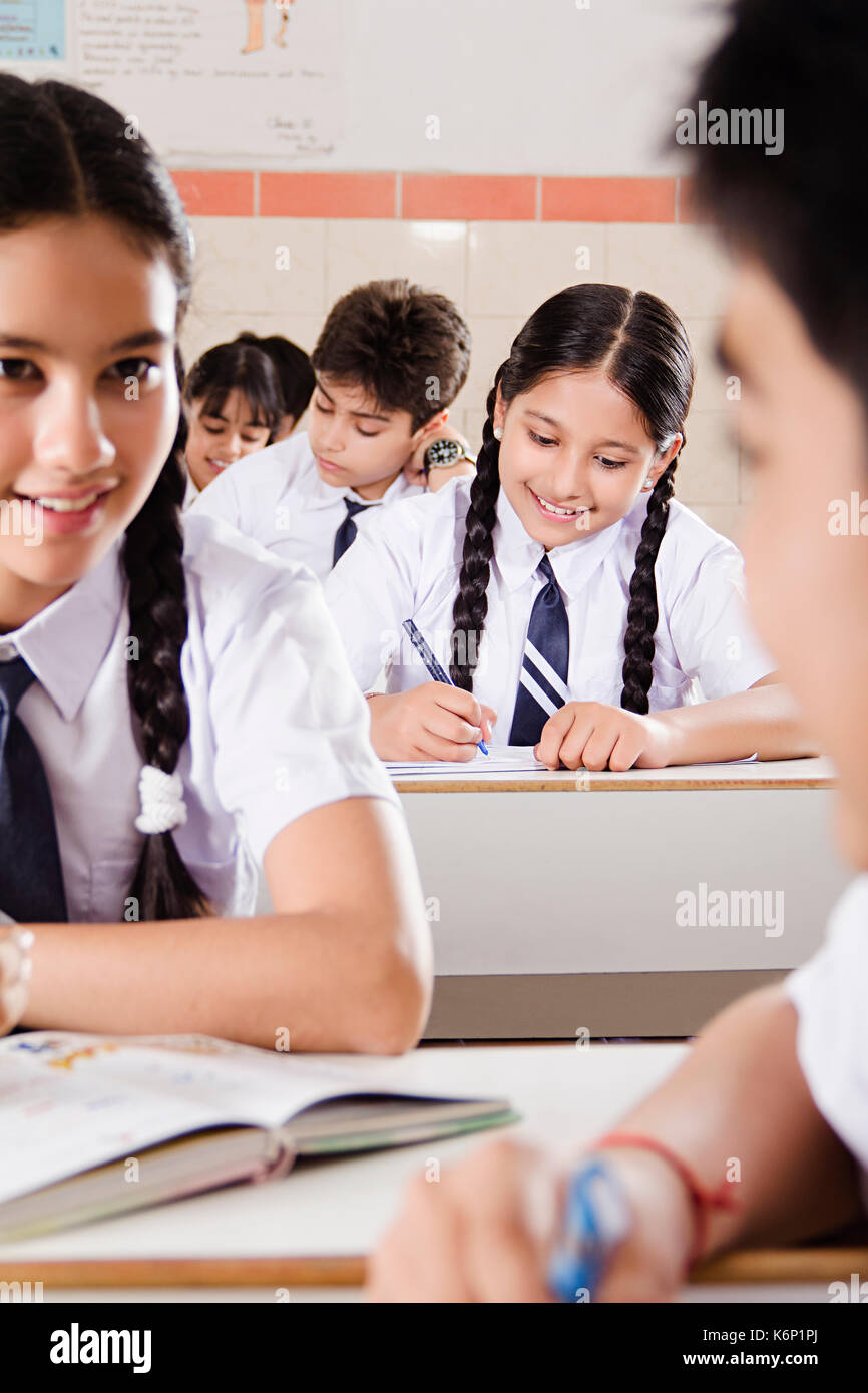 Indische Junge und Mädchen High School jugendliche Studenten sprechen Klatsch im Klassenzimmer sitzen Stockfoto