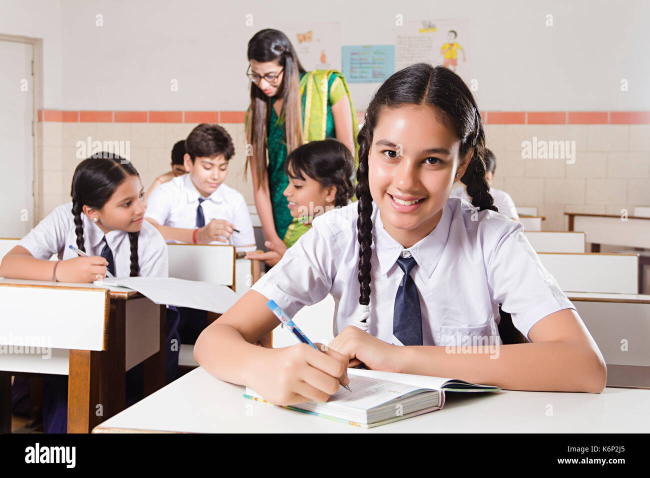 Lächelnd 1 Schule Mädchen Schüler schreiben Hinweis Buch Studieren in Klassenzimmer Stockfoto