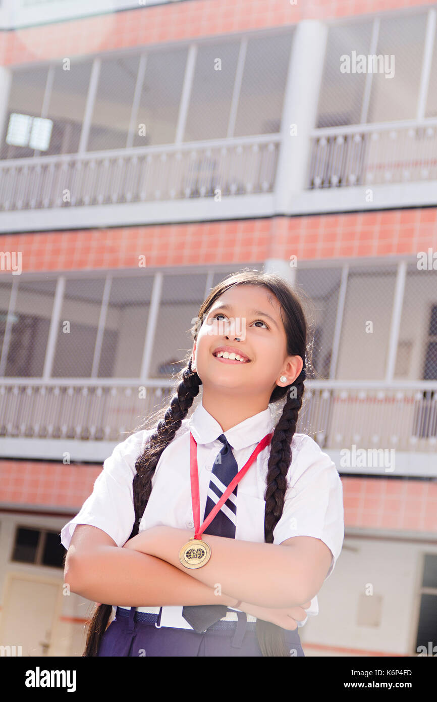 Traum 1 Indian School Mädchen Sieg Medaille und arm Gekreuzt stehen in der Schule Innenhof Stockfoto