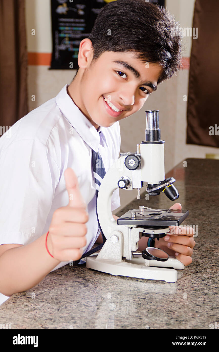 1 indischen Schule junge Student Studium Mikroskop Science Lab Forschung und zeigen Daumen hoch Stockfoto