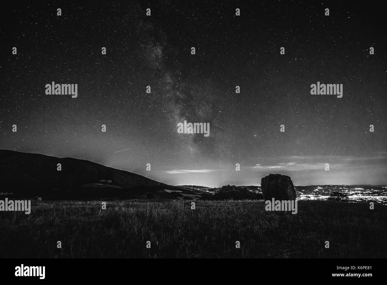 Schöne Sicht auf die Milchstraße über ein bebautes Feld und Heu Ballen Stockfoto