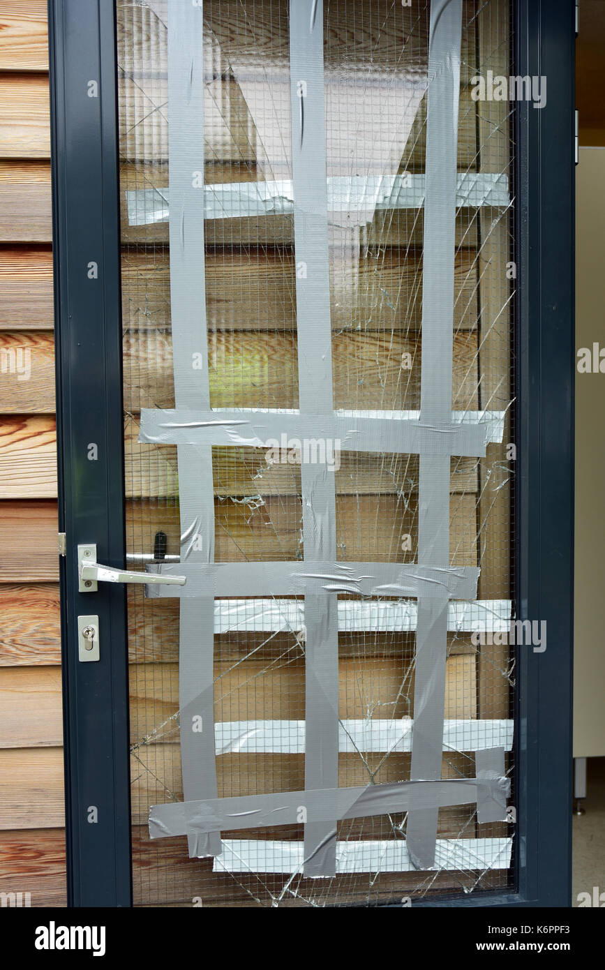 Tür fenster mit zerbrochenen Glasscheibe provisorisch mit Klebeband repariert Stockfoto