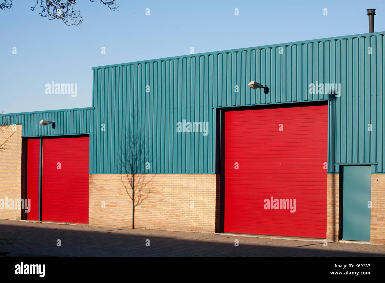 Schatten eines gerade gepflanzten Baum auf eine industrielle Gebäude Stockfoto