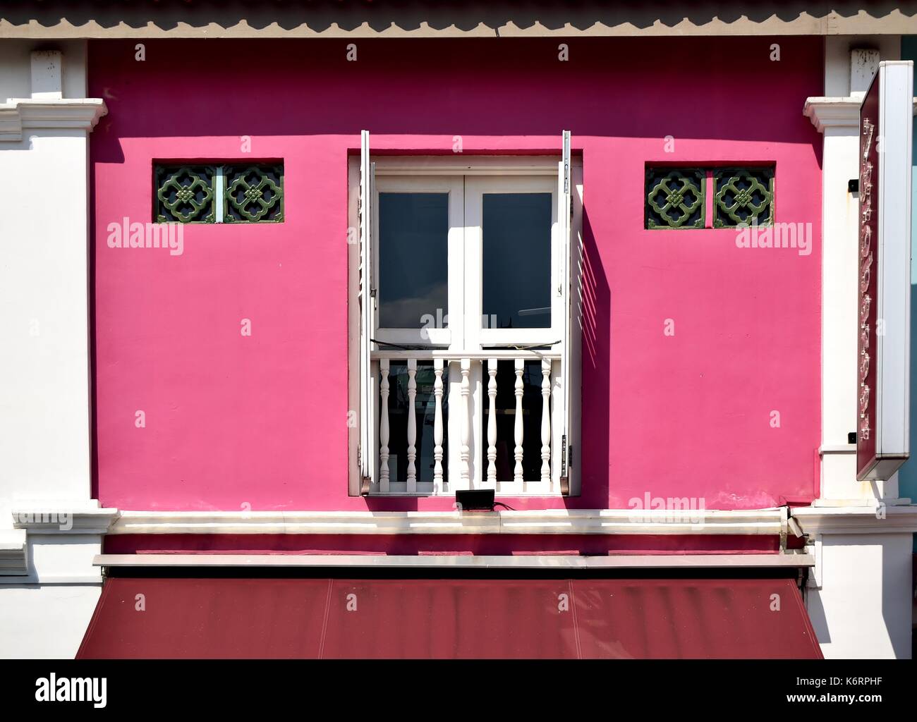Traditionelle Singapur shop Haus außen mit einem Fenster, hölzerne Lamellenfensterläden, Luftdüsen und Balkon im historischen Kampong Glam Bereich Stockfoto
