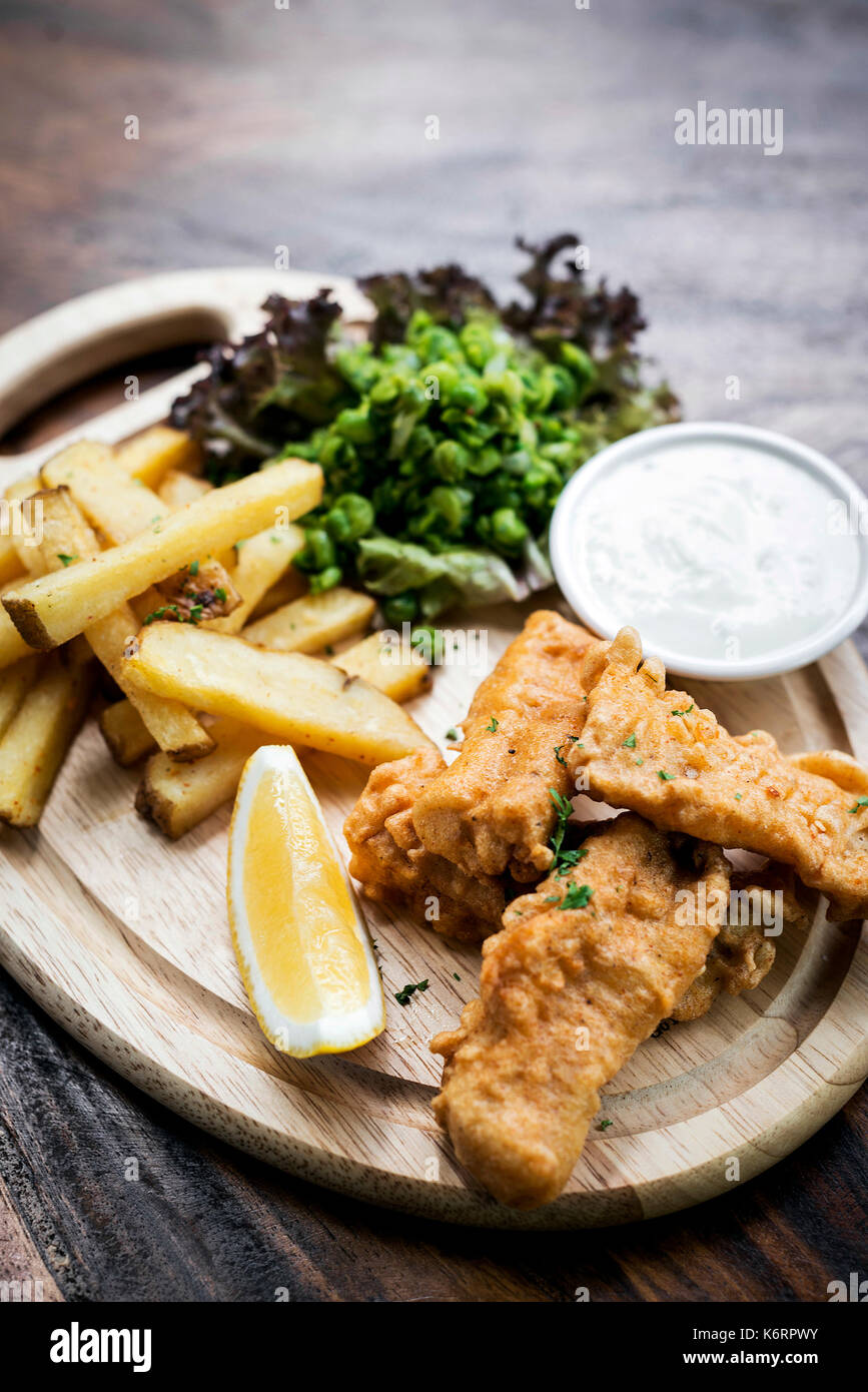 Die traditionelle Fish und Chips mit Erbsen und Sauce Tartar Stockfoto