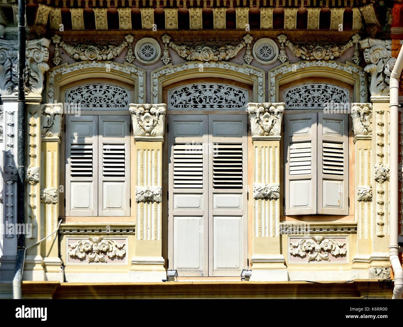 Traditionelle Singapur shop Haus außen mit Bogenfenster, hölzerne Lamellenfensterläden und verzierten Säulen im historischen Kampong Glam Bereich Stockfoto