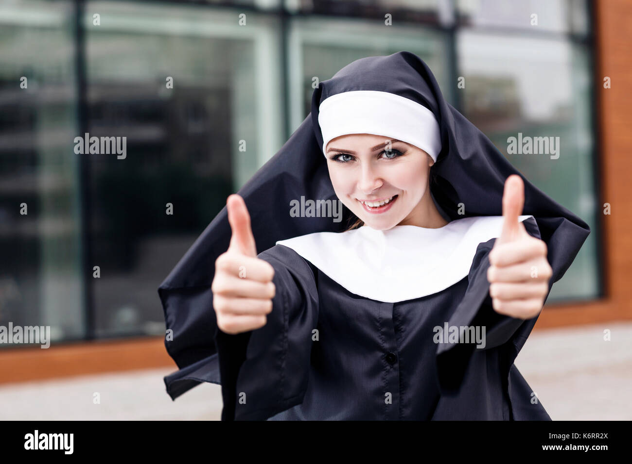 Junge glücklich Nonne Daumen hoch geben im Freien. Stockfoto