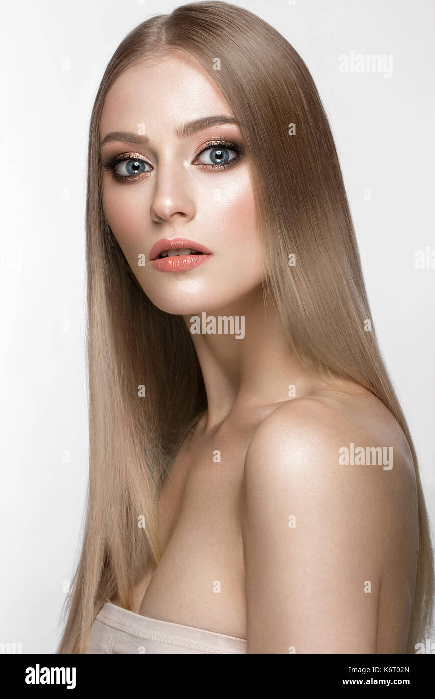 Schöne blonde Mädchen mit einem perfekt glatte Haare, und klassische Make-up. Schönheit Gesicht. Stockfoto