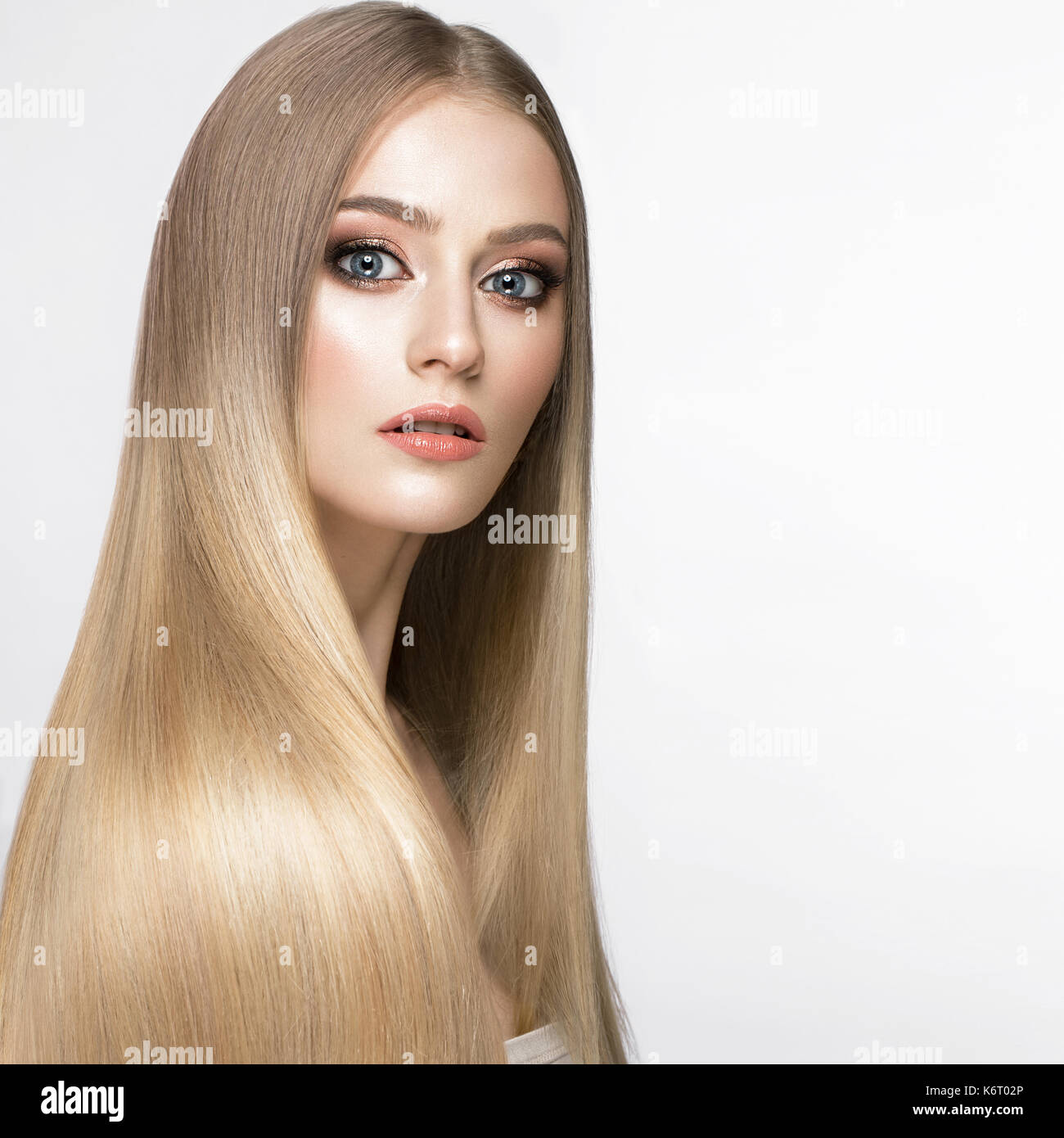 Schöne blonde Mädchen mit einem perfekt glatte Haare, und klassische Make-up. Schönheit Gesicht. Stockfoto