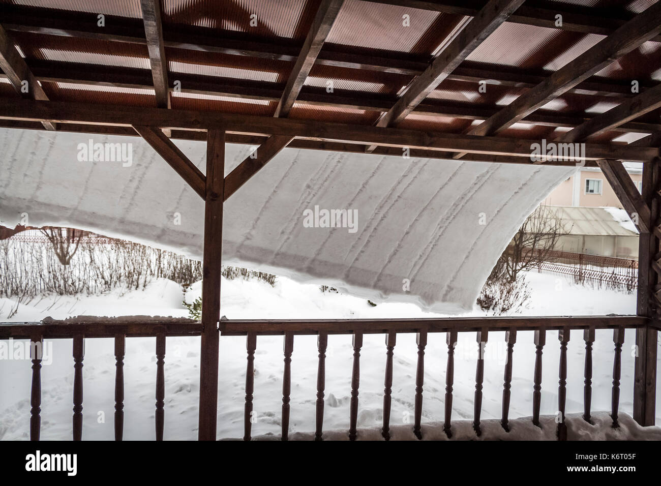 Der Schnee Dias aus dem Dach der Terrasse mit einer dicken Schicht. Stockfoto