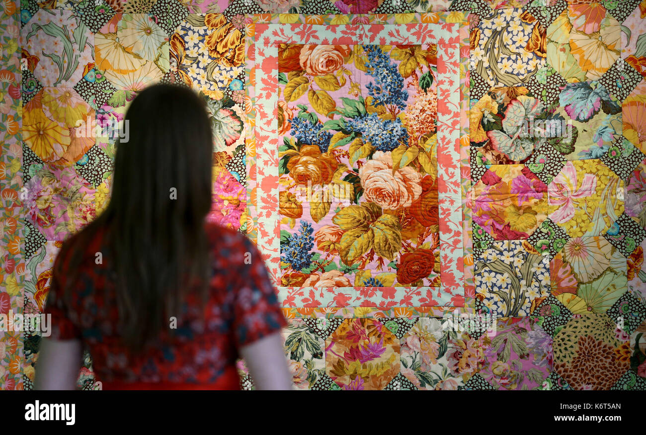 National Trust Mitarbeiter Sophie Wilkinson sieht einen Flickenteppich von textilkünstlerin Kaffe Fassett bei einem Fotoshooting für seine Show "Kaffe Fassett&Otilde; s Farbe am Mottisfont", präsentiert von seiner Karriere, die 50 Jahre bei Mottisfont in Hampshire. Stockfoto