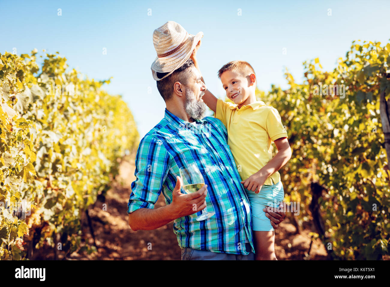 Schönen Lächeln auf den Vater und seinen niedlichen Sohn Spaß an einem Weinberg. Stockfoto