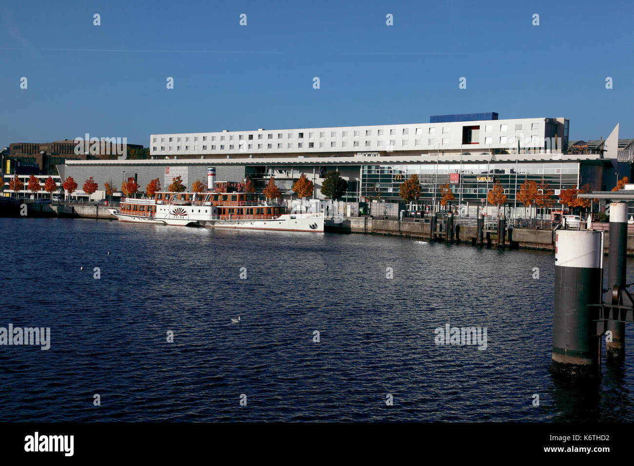 Die historische Tretboot, Freya, die im Kieler Hafen mit dem Intercity Hotel im Hintergrund günstig Stockfoto