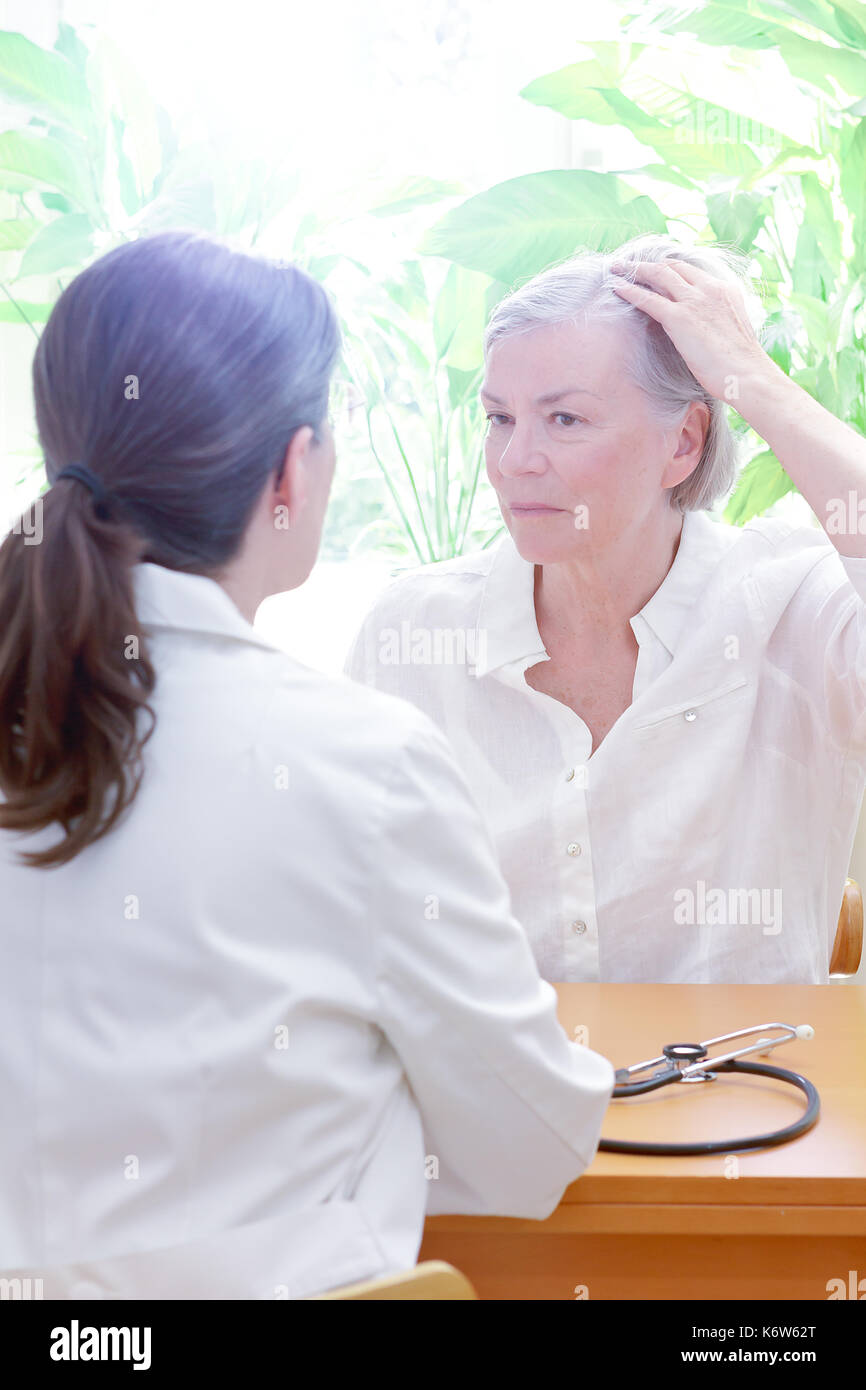 Ältere Frau zeigt ihre schütteres Haar oder Haarausfall zu Ihrer Ärztin oder Arzt, kopieren Raum Stockfoto