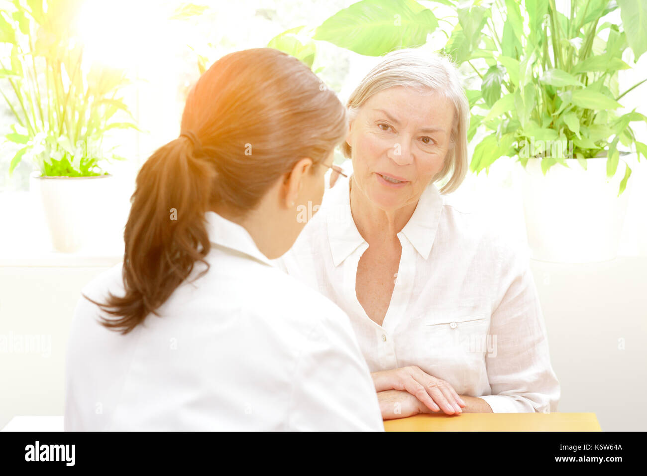 Ältere Patienten etwas diskutieren im Vertrauen mit Ihrer Ärztin für Geriatrie an einem sonnigen Nachmittag, freundliche Atmosphäre Stockfoto