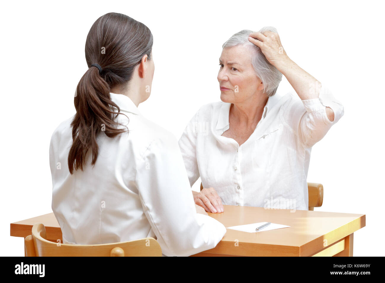 Ältere Frau zeigt ihre schütteres Haar oder Haarausfall zu Ihrer Ärztin, auf weißem Hintergrund Stockfoto