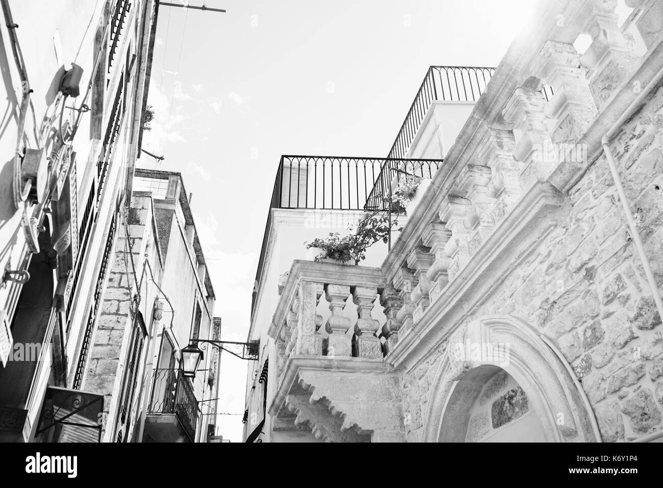 Schwarz und Weiß, von Balkonen auf den kleinen Straßen von Ostuni, Apulien, Italien Stockfoto