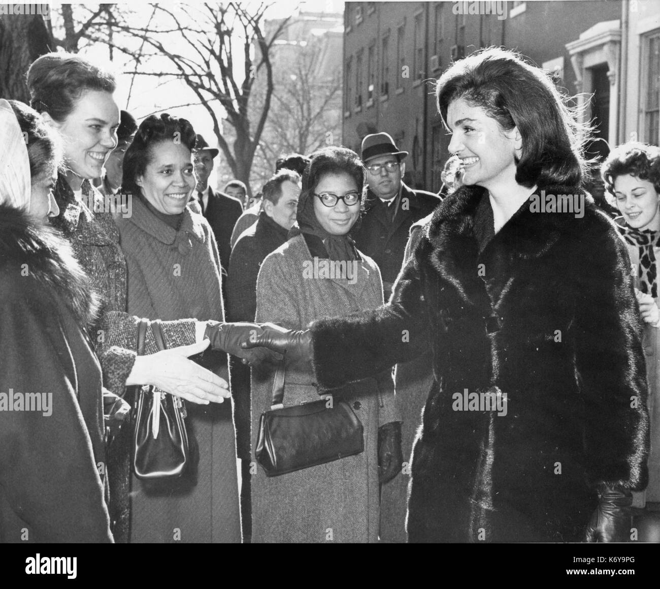 Frau Kennedy grüßt Gratulanten in der Nähe des Weißen Hauses, nachdem Sie die Büros besucht hatte, in der Nähe von dort, wo Freiwillige, um die Flut von mail handling wurden nach der Ermordung ihres Mannes erhalten. Frau Kennedy besuchte die Büros der Freiwilligen für ihre Hilfe danken. Washington, DC, 1/10/64. Stockfoto