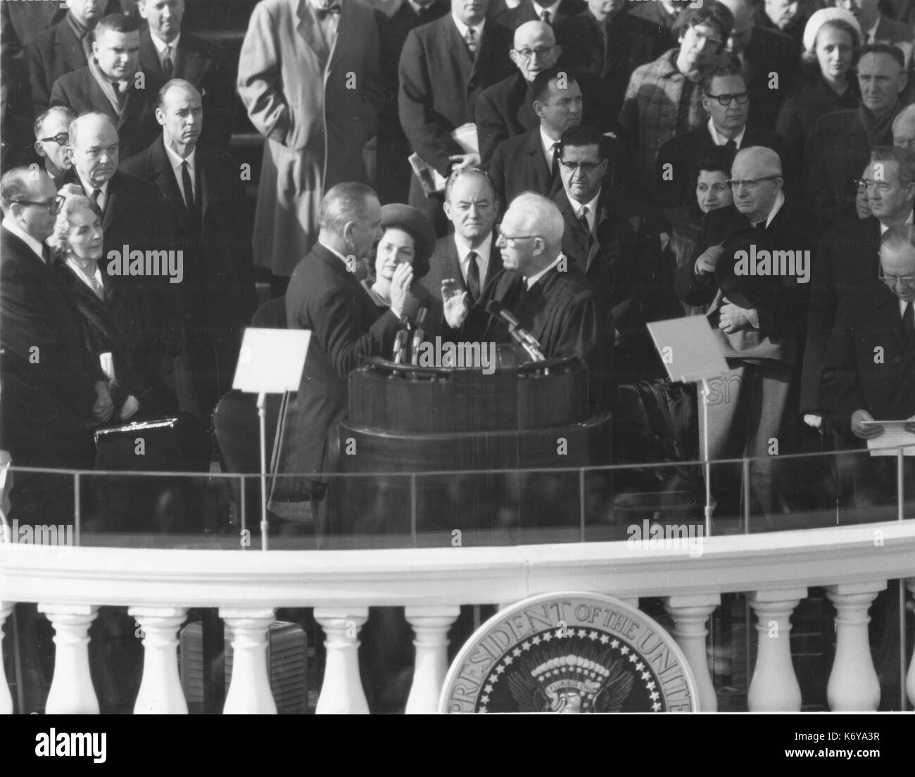 Lyndon Baines Johnson nimmt den Amtseid als Präsident der Vereinigten Staaten von Chief Justice Earl Warren am 20. Januar 1965, im Capitol. Nur über themn sind Frau Johnson und Vizepräsident Hubert H. Humphrey. Washington, DC. 1965. Stockfoto