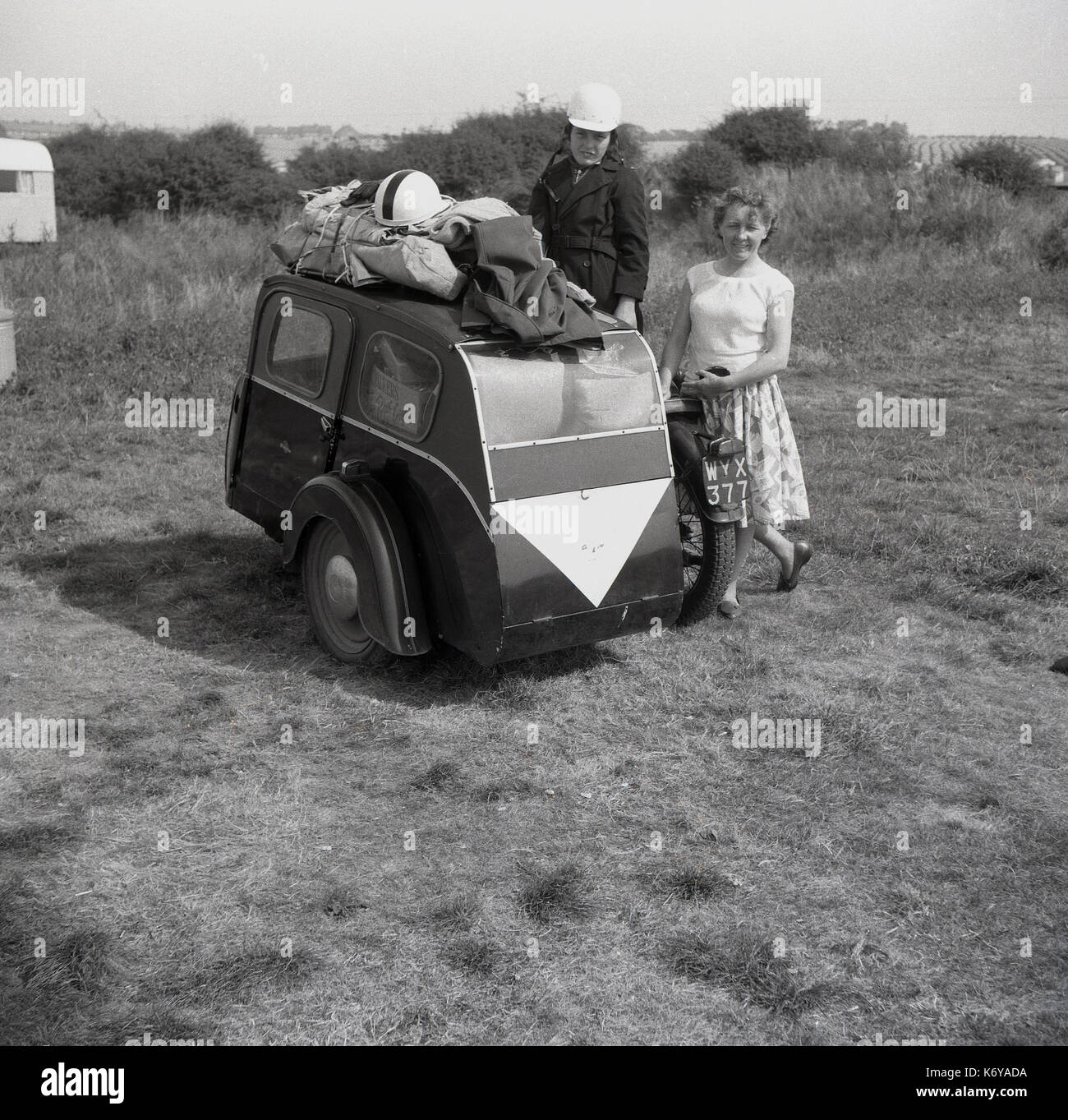 Anfang der 1950er Jahre, Großbritannien, Mutter und Sohn stehen außerhalb in einer Wiese neben Ihrem Motorrad und zwei Rädern Seitenwagen, die mit Gepäck sowohl innen als auch auf dem Dach geladen wird. Die post-WW 2 Jahre in Großbritannien sah einen Boom in diesem preiswerten Form der Fortbewegung. Stockfoto