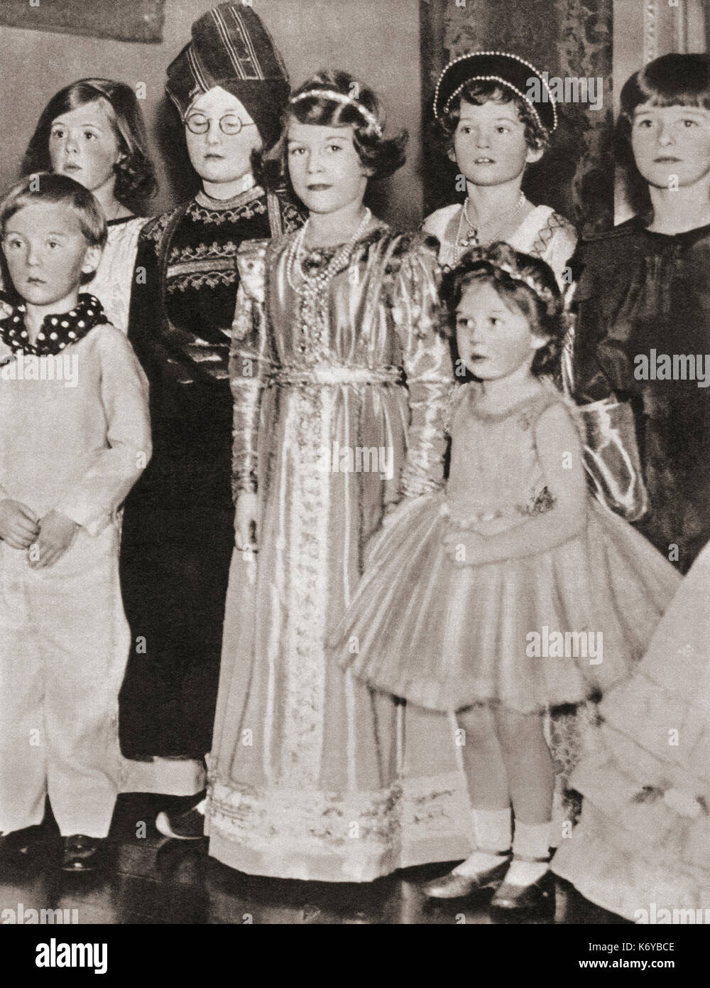 Prinzessin Elizabeth von York, im Tudor-Kleid und Prinzessin Margaret im Märchen-Kostüm, auf einer Party im Jahr 1934. Prinzessin Elisabeth von York, zukünftige Elisabeth II., 1926 - 2022. Königin des Vereinigten Königreichs. Prinzessin Margaret, zukünftige Gräfin von Snowden, 1930 – 2002. Aus dem Krönungsbuch von König Georg VI. Und Königin Elisabeth, veröffentlicht 1937. Stockfoto