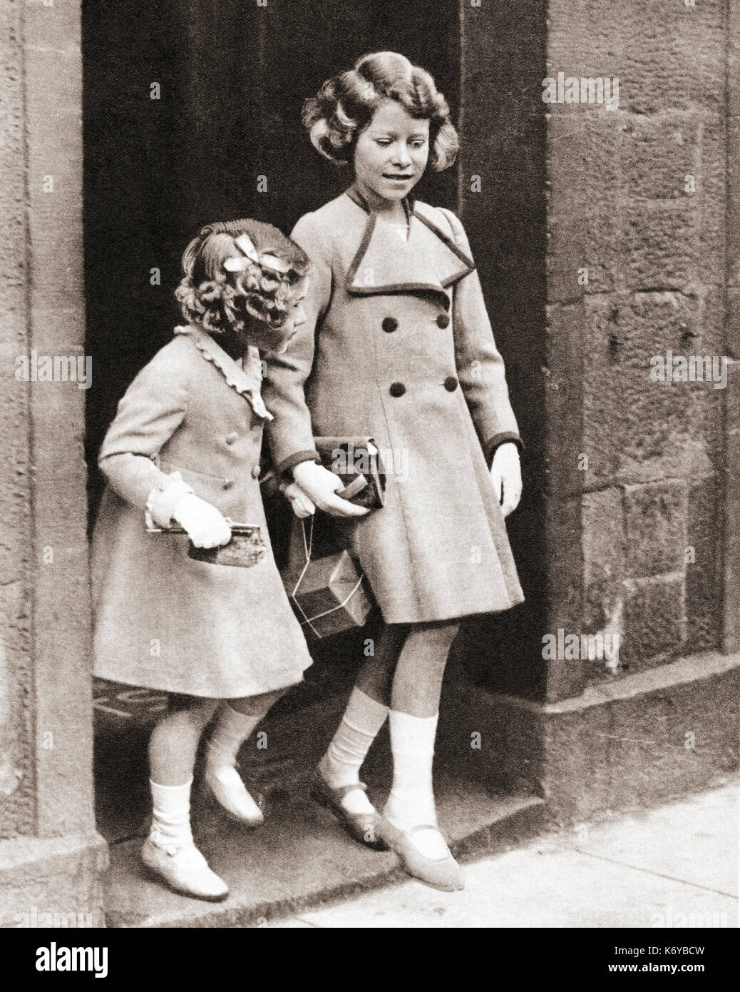 Prinzessin Elizabeth, rechts, und ihre Schwester Prinzessin Margaret im Jahr 1935. Prinzessin Elisabeth von York, zukünftige Elisabeth II.,1926 - 2022. Königin des Vereinigten Königreichs. Prinzessin Margaret, zukünftige Gräfin von Snowden, 1930 – 2002. Aus dem Krönungsbuch von König Georg VI. Und Königin Elisabeth, veröffentlicht 1937. Stockfoto