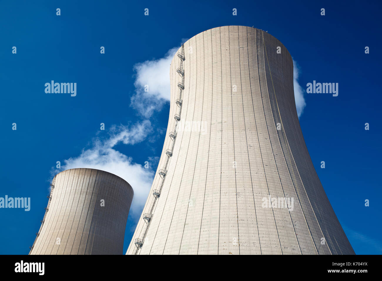 Zwei Kühltürme mit Dampf gegen den blauen Himmel. Stockfoto