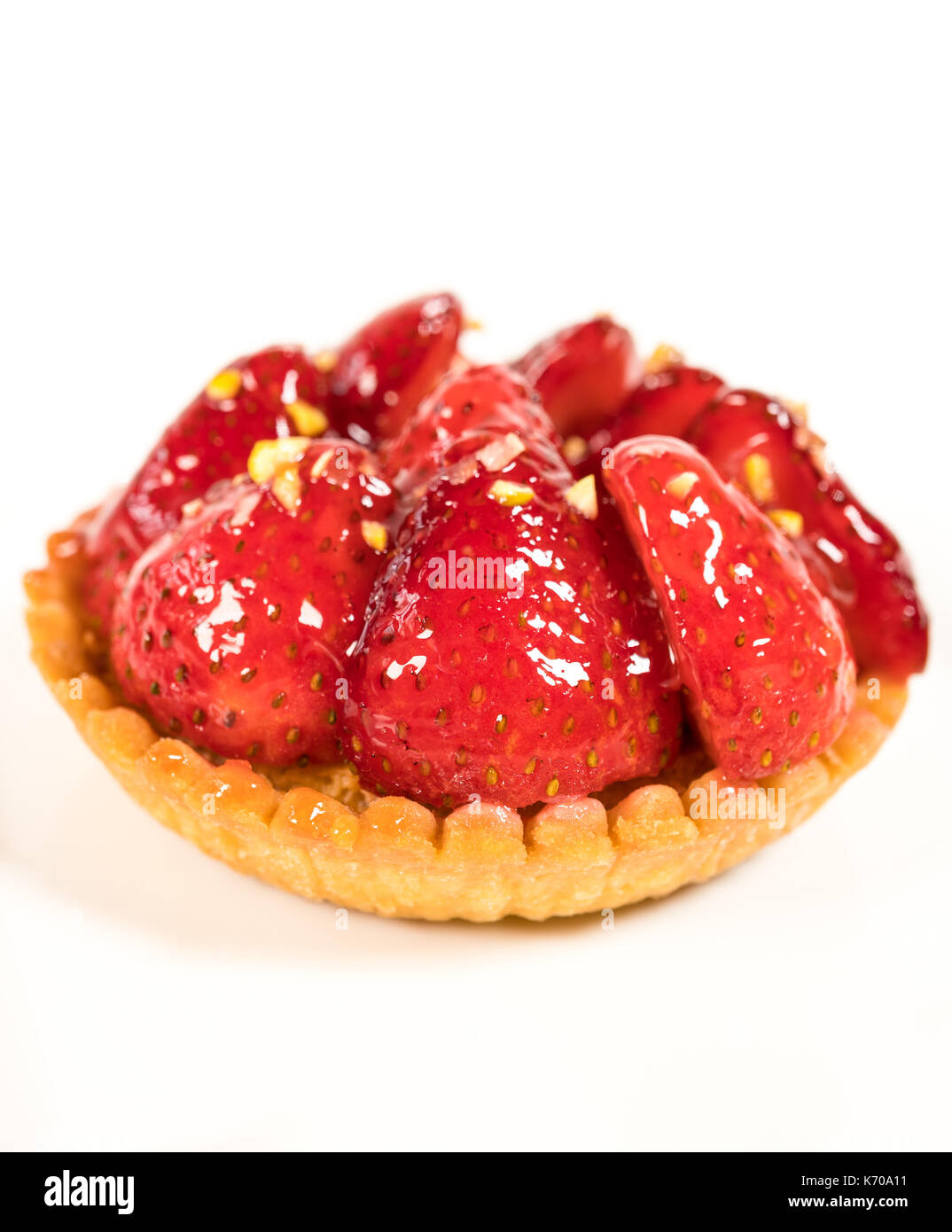 Ein Stück Erdbeere Törtchen mit gehackten Mandeln oben auf weißem Hintergrund Stockfoto