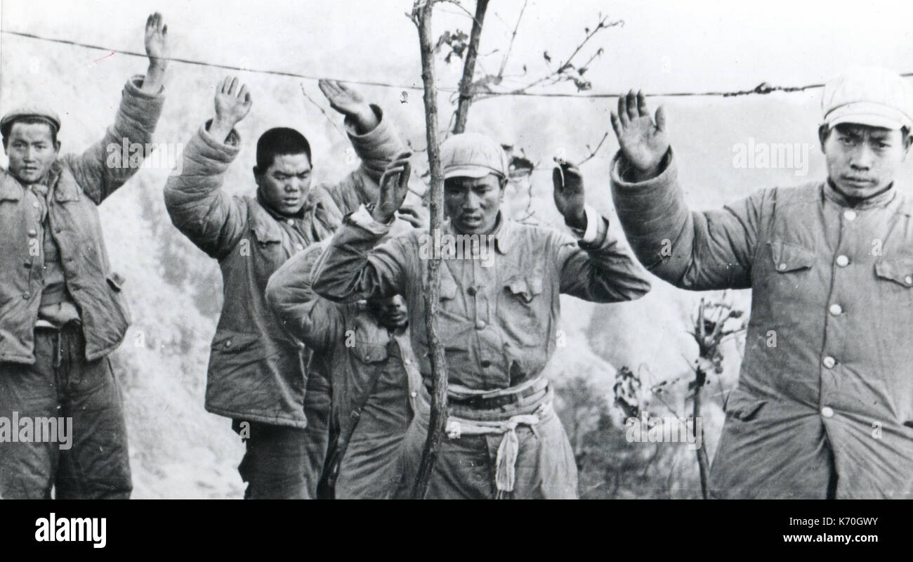 Januar 1953, Korea - Chinesische Kommunistische Truppen appproach Republik Korea Soldaten (nicht abgebildet) mit den Händen im Zeichen der Hingabe. Kommunisten schlüpfte unter Stacheldraht Kennzeichnung der Vereinten Nationen Seite der Fronten. Stockfoto