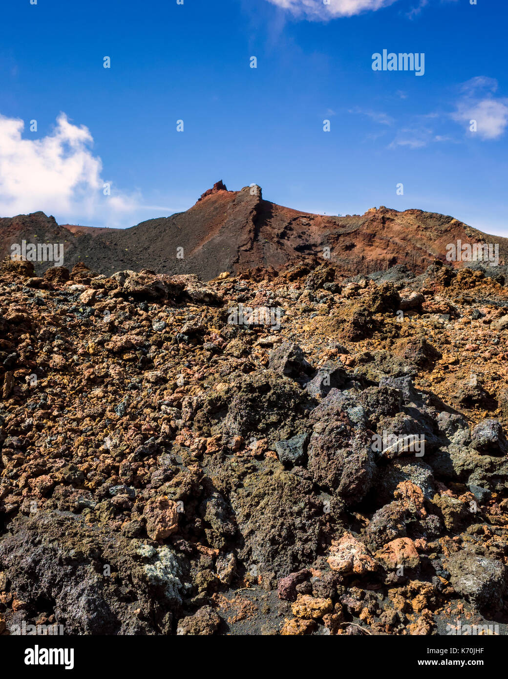 Los Volcanes de Teneguía, Fuencaliente, La Palma. Ein Blick auf die karge Landschaft rund um den Vulkan. Es ist möglich, sich vorzustellen, wie die Lava hier auf dem Land niedergelassen nach vorherigen Ausbruch des Vulkans. Die Felsen sind sehr unterschiedlich mit Braun in den Vordergrund in Richtung rot- und verkohlte Kohle hinter. Dies macht einen großen Kontrast mit dem blauen Himmel im Hintergrund. Keine erosion sichtbar ist und die Natur hat noch seinen Kurs mit Vegetation zu nehmen. Stockfoto