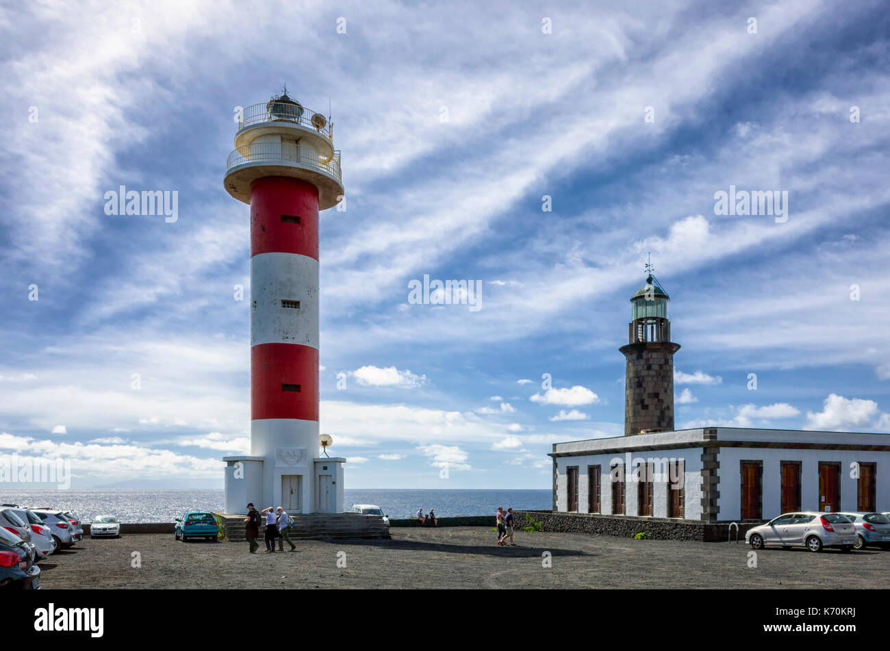 Fuencaliente, La Palma. Kanarische Inseln Spanien. Die fuencaliente Leuchtturm ist ein aktiver Leuchtturm auf der Insel La Palma Auf den Kanarischen Inseln. Es ist die zweite Leuchtturm an diesem Standort, die am südlichen Ende der Insel Marken gebaut werden. Der alte Leuchtturm im Hintergrund gesehen werden. Das Besucherzentrum gebaut wurde, zu fördern und die Bevölkerung über die marine Umwelt erziehen. Weiße Wolken Streifen über den tiefblauen Himmel für eine dramatische Szene. Mit einer Ricoh GRII Kamera fotografiert. Stockfoto