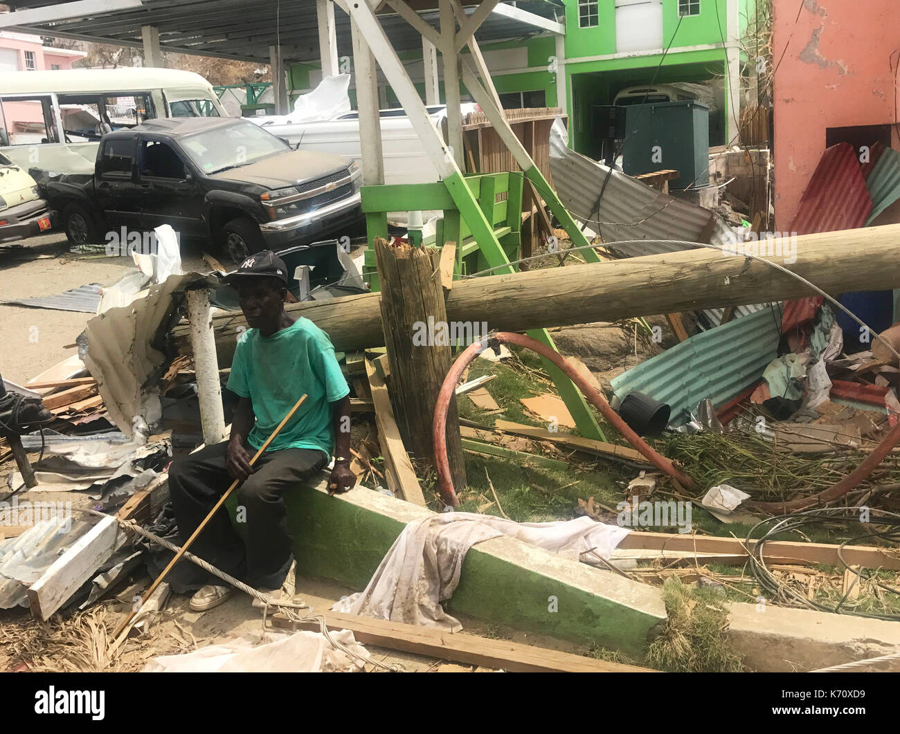 Ein Mann sitzt unter einigen der Schäden in Tortola auf den British Virgin Islands nach dem Hurrikan Irma der Region zerschlagen. Stockfoto