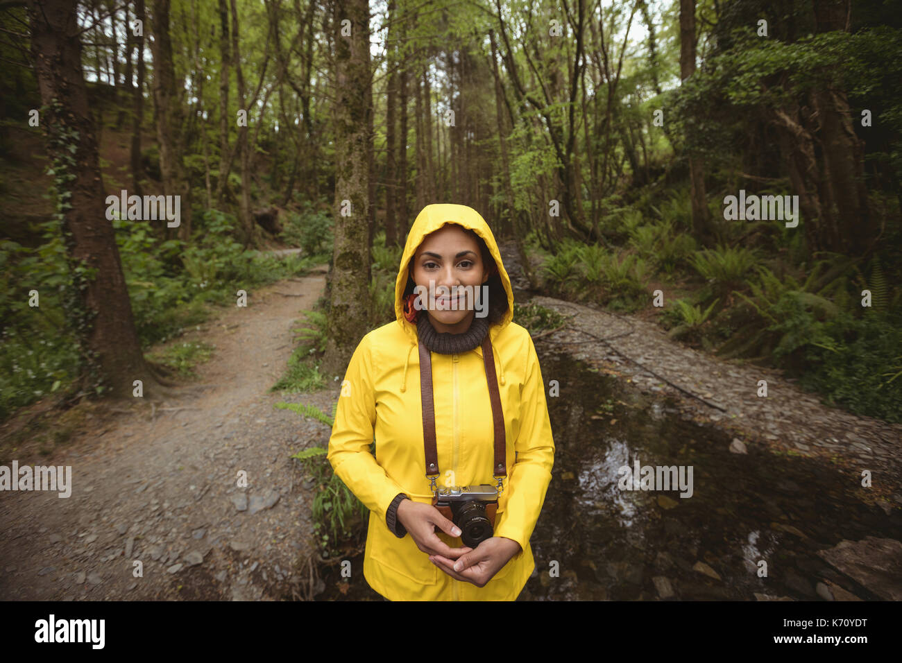 Portrait von weiblichen Wanderer stehen mit Kamera im Wald Stockfoto