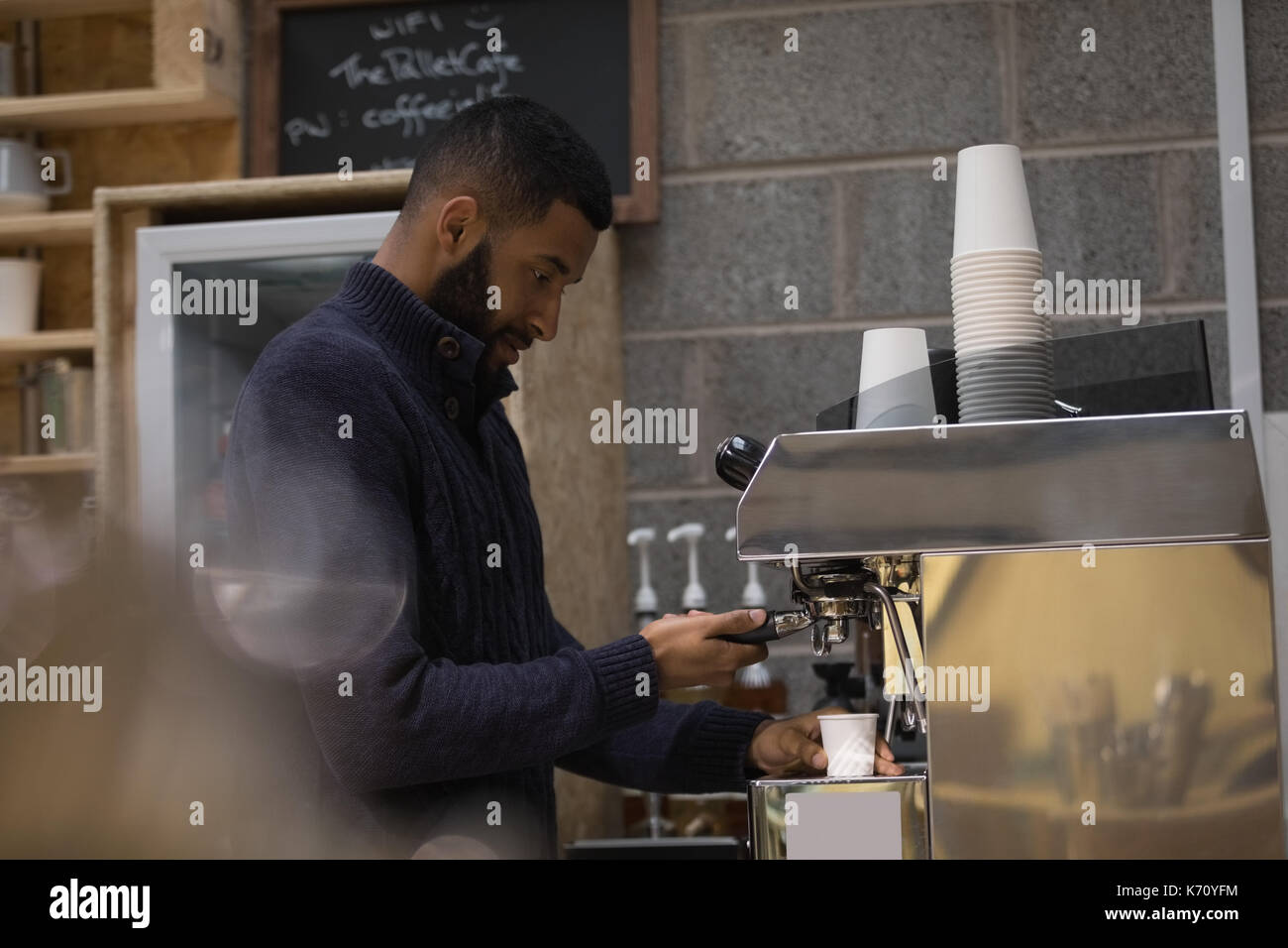 Seitenansicht der männlichen Inhaber Kaffee im Cafe Stockfoto