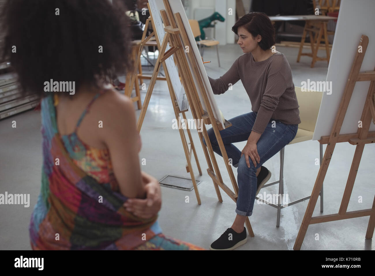Künstlerin zeichnen eine Skizze der Frau auf Leinwand in art studio Stockfoto