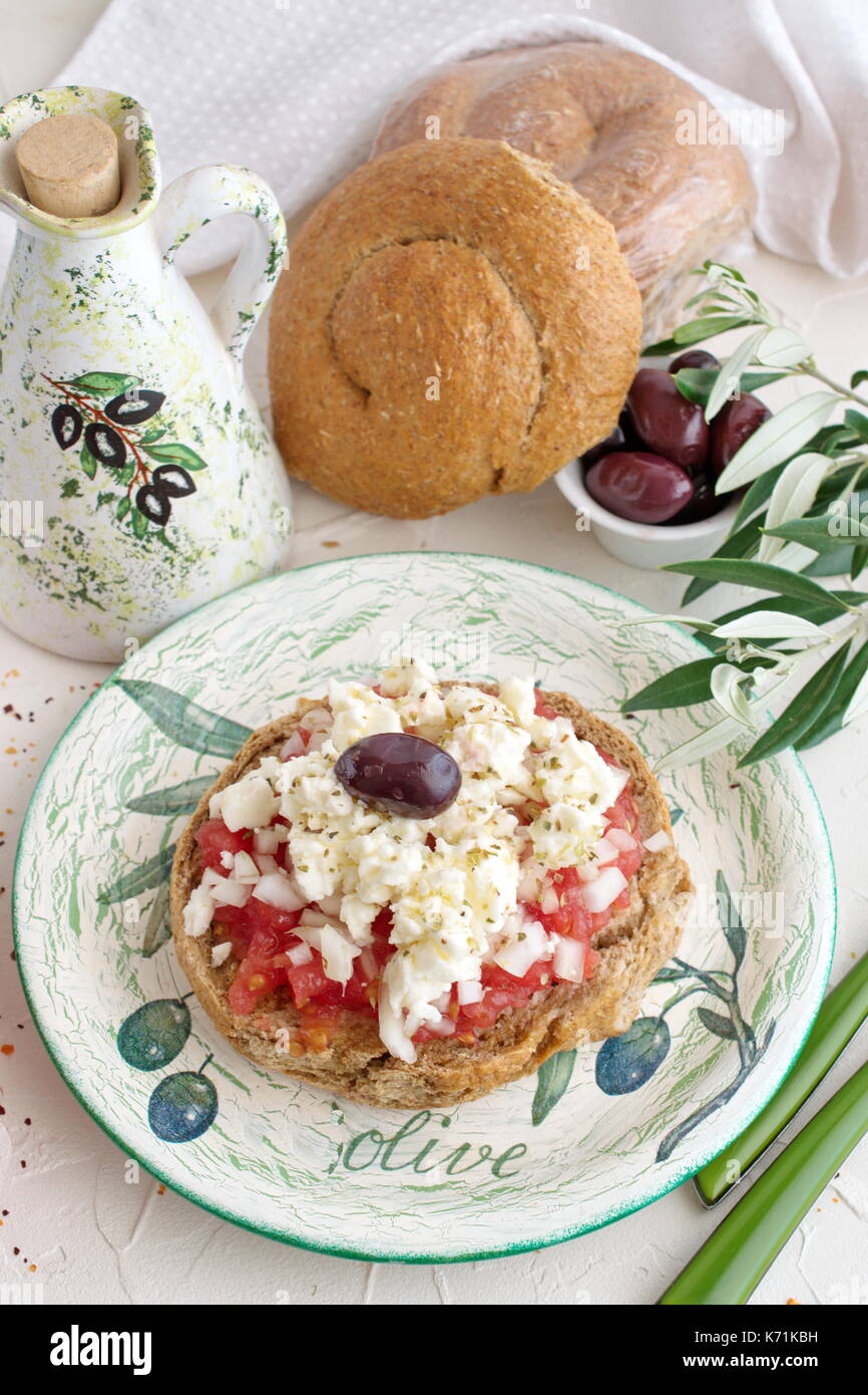 Dakos traditionelle griechische Vorspeise auf einem traditionellen Platte mit keramischen Olivenöl jar, trockenen Roggen Brot, Oliven und Olivenöl. Gesunde Ernährung Konzept. Stockfoto