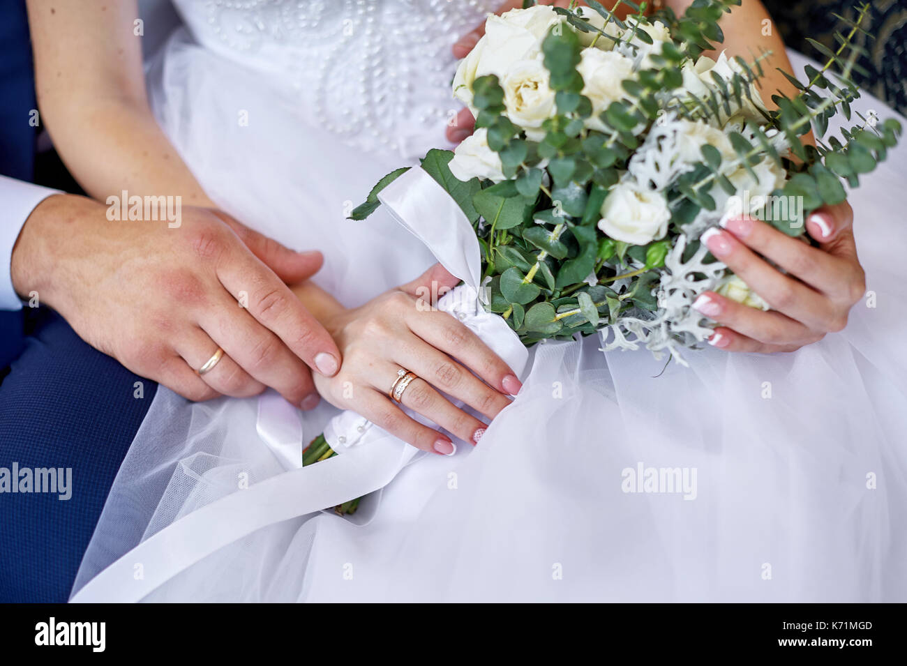 Bräutigam die Braut mit einer Hochzeit Blumenstrauß für einen Spaziergang Stockfoto