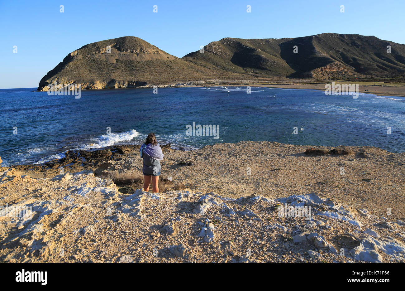 Frau auf der Suche nach Anzeigen Playa de Playazo, Las Negras, Naturpark Cabo de Gata, Almeria, Spanien Stockfoto