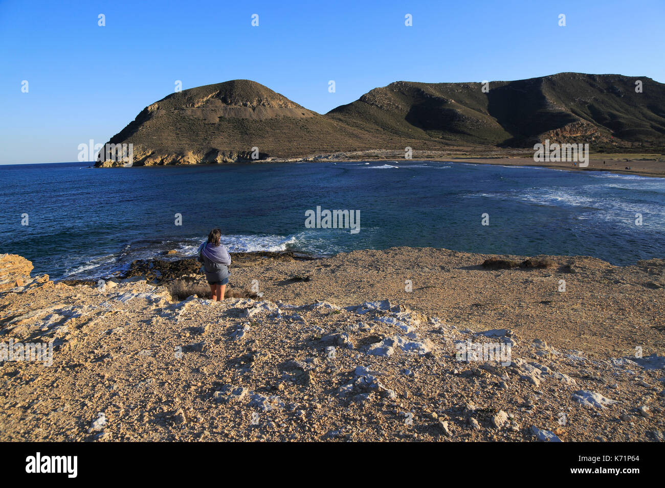 Frau auf der Suche nach Anzeigen Playa de Playazo, Las Negras, Naturpark Cabo de Gata, Almeria, Spanien Stockfoto