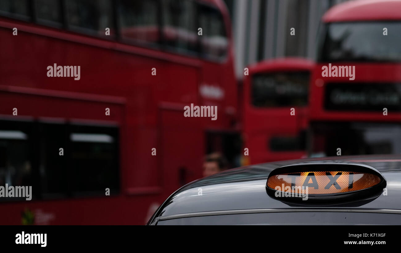 Nahaufnahme der Taxi Schild auf einem traditionellen Londn cab mit roten Doppeldecker im Hintergrund in den Straßen von London, Großbritannien Stockfoto